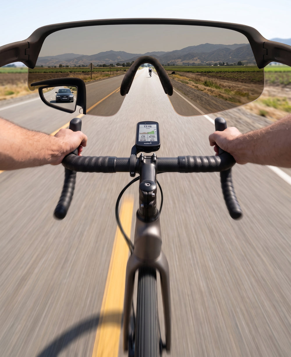 POV through TriEye eyewear on a road bike, portrait: the full width of the frame with a car visible in the built-in mirror at the lower left