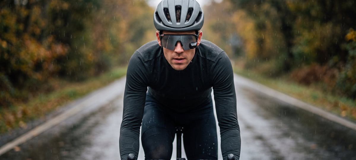 Road cyclist riding toward the camera in autumn rain, wearing TriEye The View with the rear-view mirror set into the lower outer corner of the single shield lens