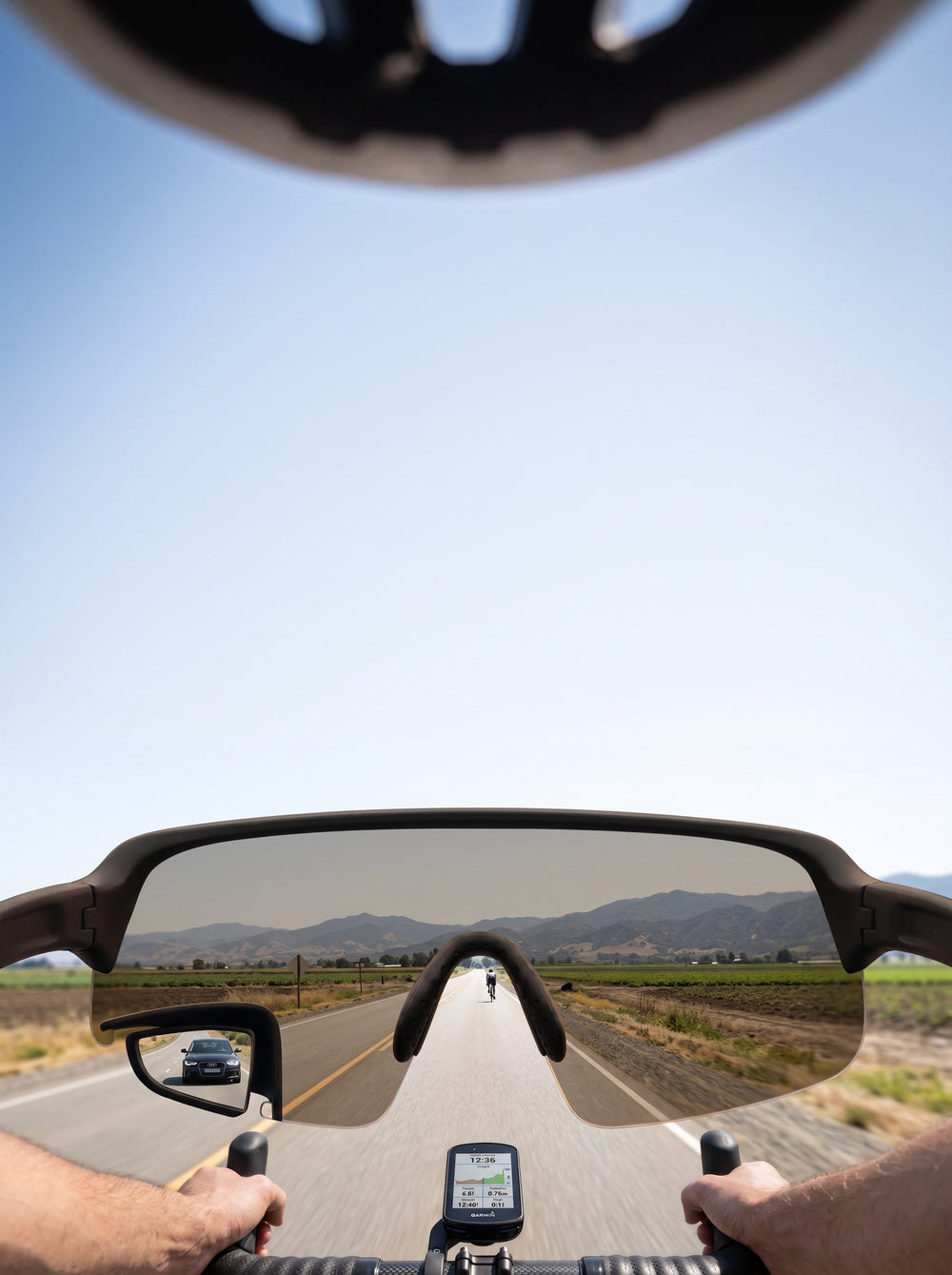 POV through TriEye eyewear on a road bike, portrait: the full width of the frame with a car visible in the built-in mirror at the lower left