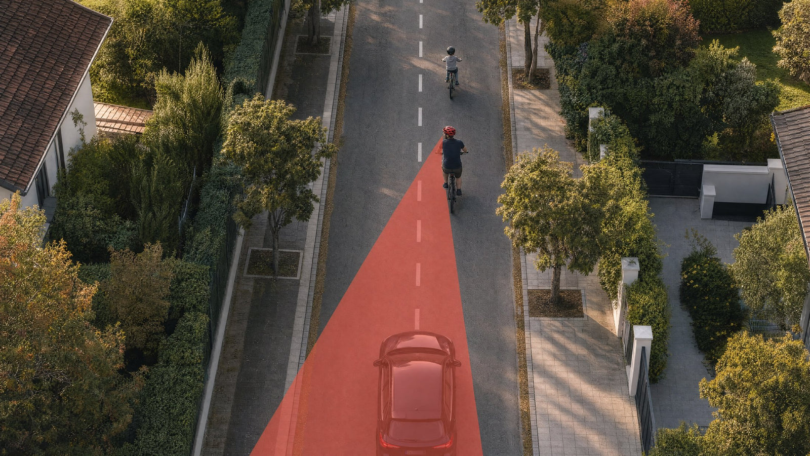 Drone view: a child rides ahead, the parent behind, a car inside the mirror field of view