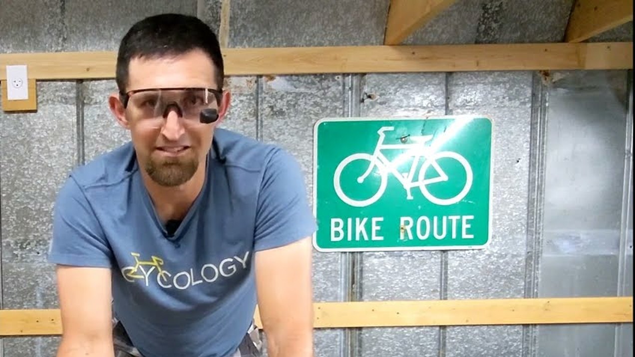 A cyclist wearing TriEye eyewear demonstrates how to set the angle of the rear-view mirror